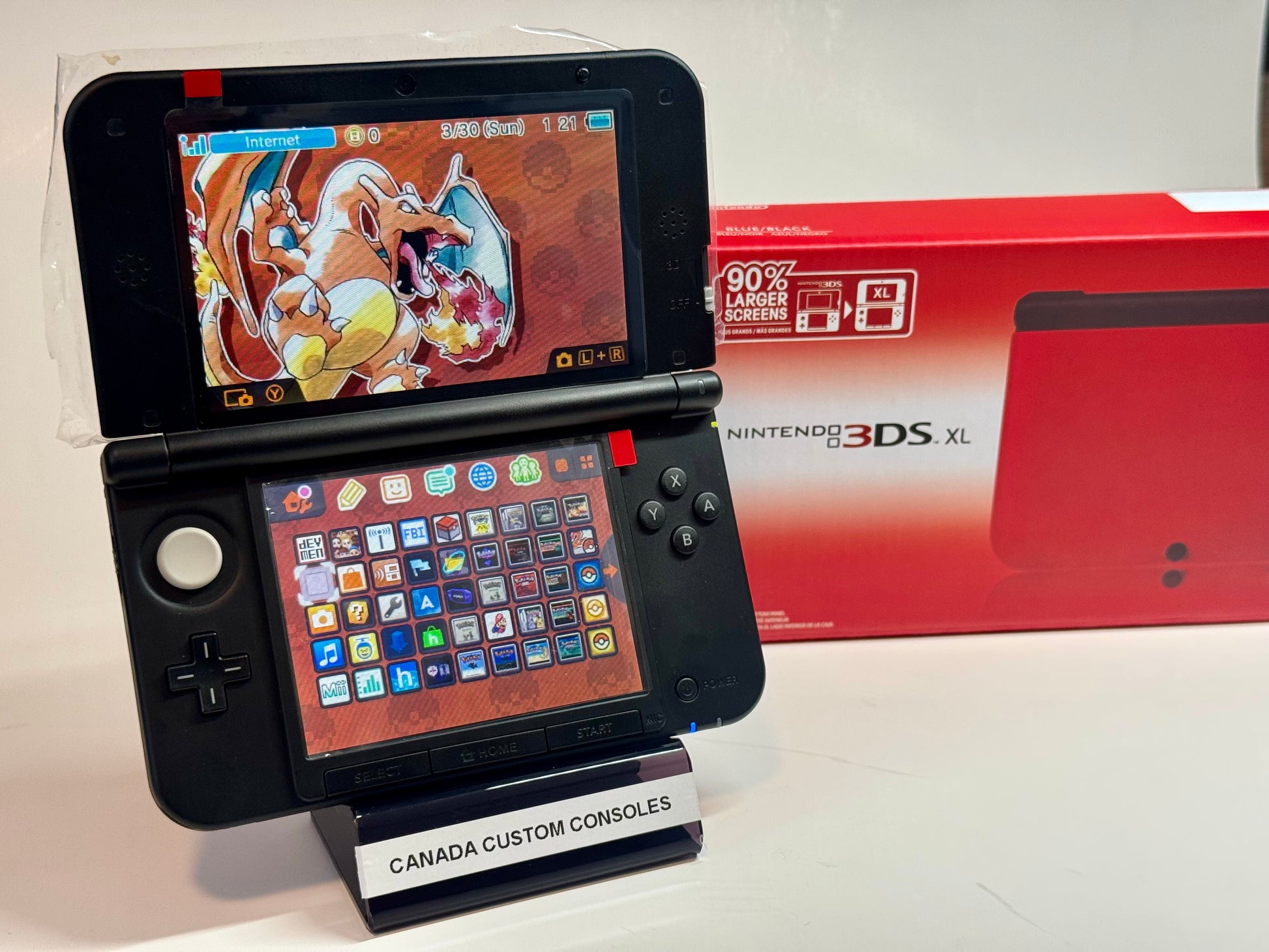 A refurbished Nintendo 3DS XL — Red/Black | Fully Modded sits atop a “Canada Custom Consoles” stand, with its menu icons visible. A red 3DS XL box is in the background—perfect for retro gaming fans.