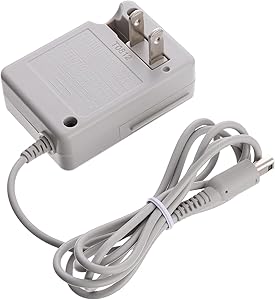 The Nintendo DSi / 2DS / 3DS Replacement Charger is a gray AC adapter with two metal prongs and a coiled cord secured by a twist tie; perfect for replacing lost or damaged chargers.