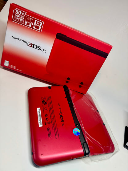 A refurbished Nintendo 3DS XL — Red/Black (fully modded) lies face down in a plastic sleeve beside its matching branded box, highlighting this collectible retro handheld console.