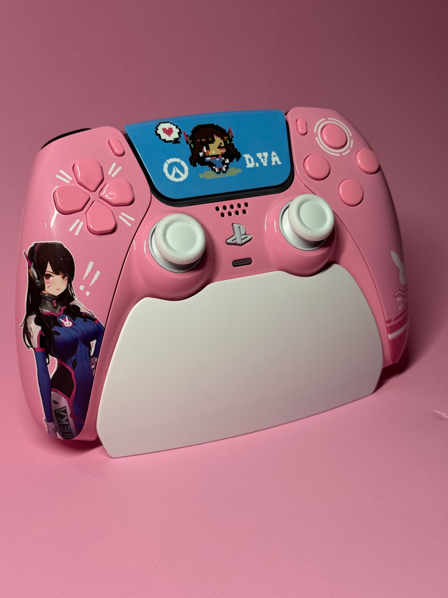 The D.Va Overwatch Custom PS5 Controller | Hall Effect Sticks | Pink features Overwatch art and rests on a matching charging stand, making it an ideal choice for fans who want stylish looks and top performance.