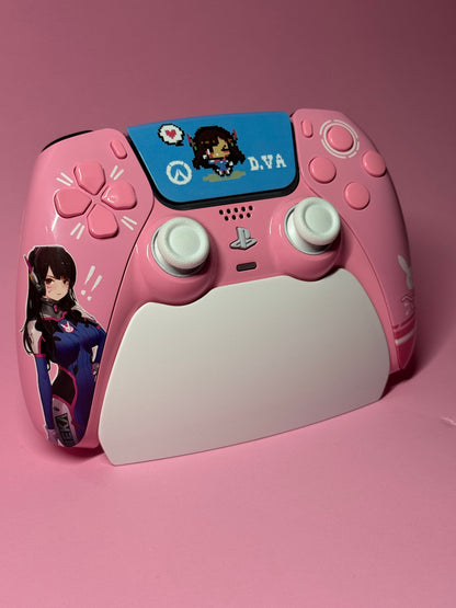 The D.Va Overwatch Custom PS5 Controller | Hall Effect Sticks | Pink features Overwatch art and rests on a matching charging stand, making it an ideal choice for fans who want stylish looks and top performance.