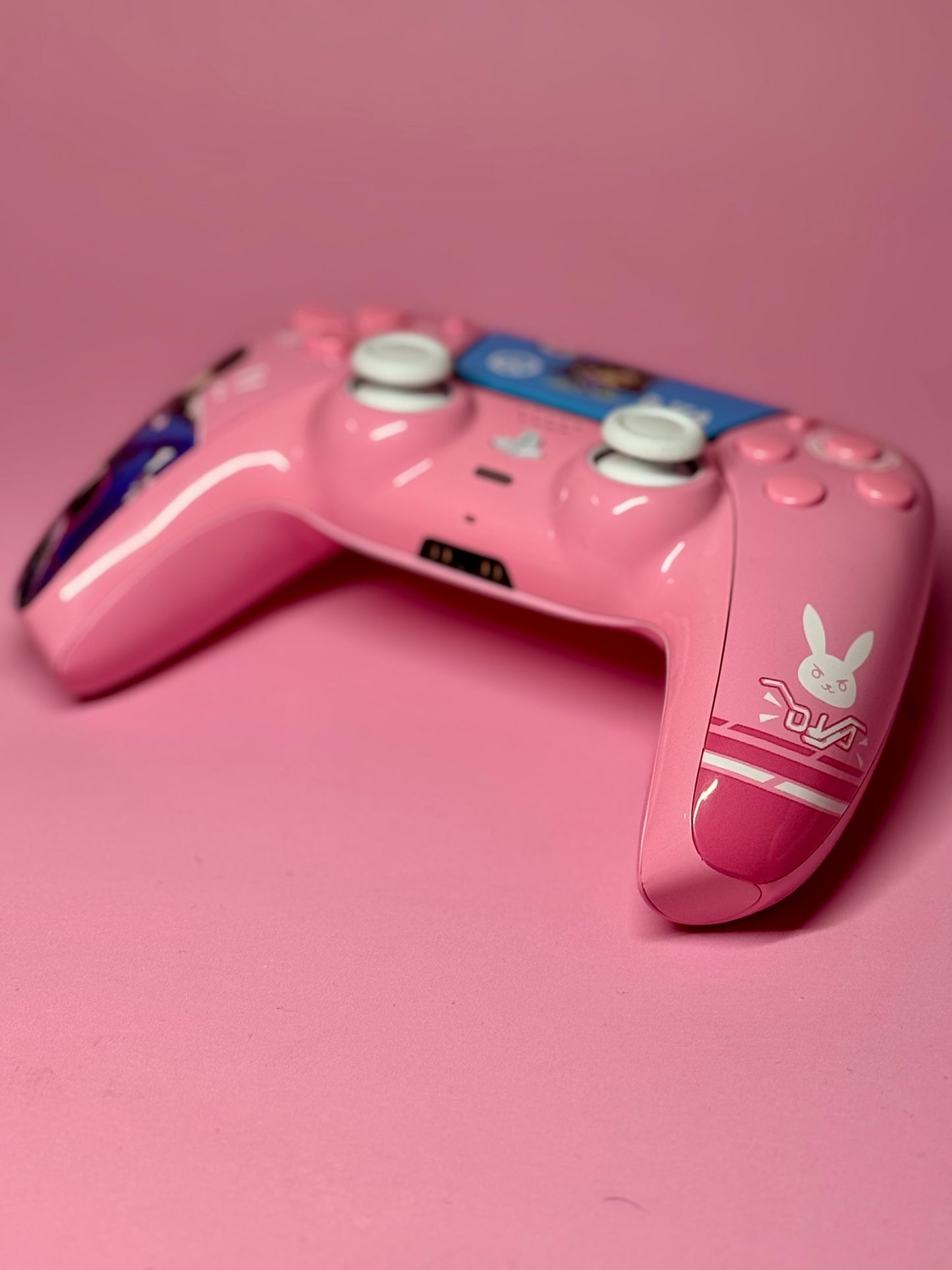 The D.Va Overwatch Custom PS5 Controller features Hall Effect sticks, white buttons, a pink design with D.Va graphics, and a white bunny logo.