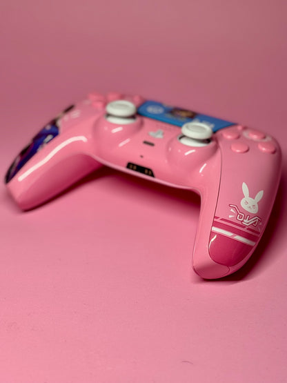 The D.Va Overwatch Custom PS5 Controller features Hall Effect sticks, white buttons, a pink design with D.Va graphics, and a white bunny logo.