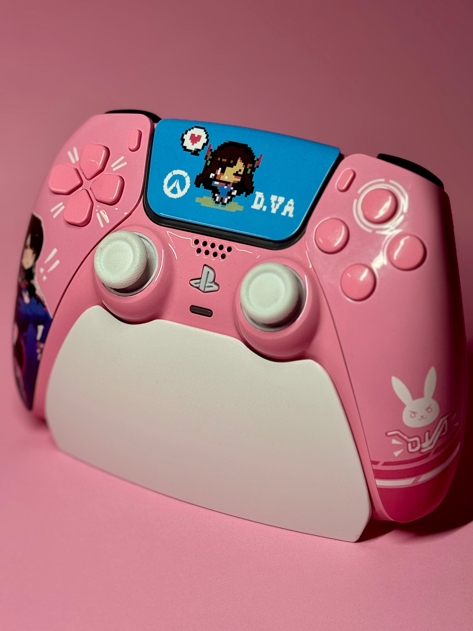 The D.Va Overwatch Custom PS5 Controller | Hall Effect Sticks | Pink features cartoon D.Va and bunny logo details on a matching pink surface, with a touchpad showcasing pixel art D.Va and a heart for added charm.