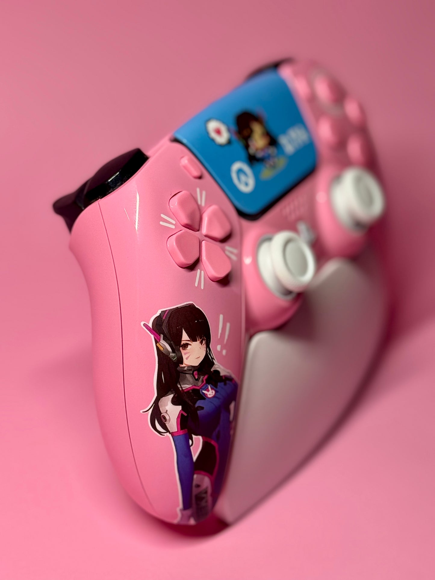 The D.Va Overwatch Custom PS5 Controller in pink features Hall Effect sticks for precise gaming and is decorated with a matching anime-style character on a pink and white design.