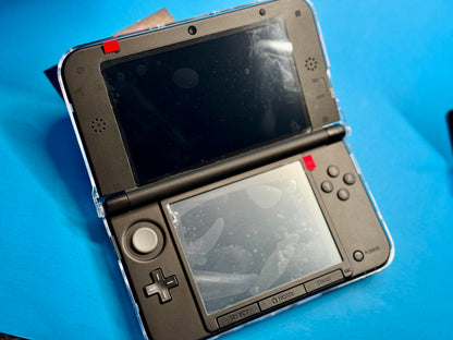 A fully modded Nintendo 3DS XL — Blue/Black with visible screen smudges sits open on a bright blue surface.