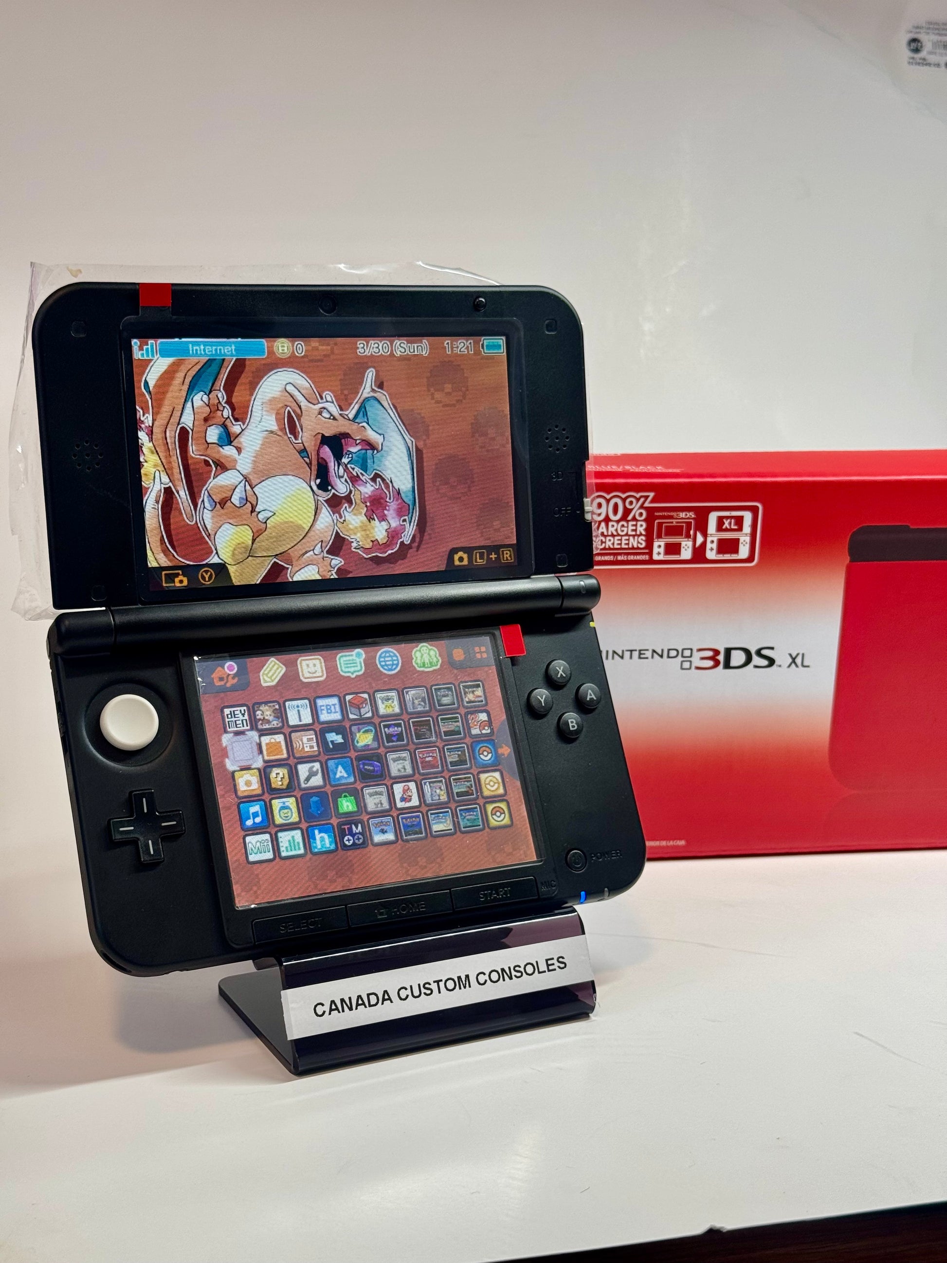 A refurbished Nintendo 3DS XL (Red/Black), fully modded with a custom Pokémon Charizard theme and colorful app icons, is displayed. The red box and a stand reading "CANADA CUSTOM CONSOLES" highlight this retro gaming console.