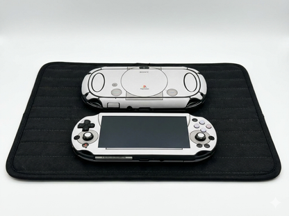 Two gaming consoles on a black mat with a white background