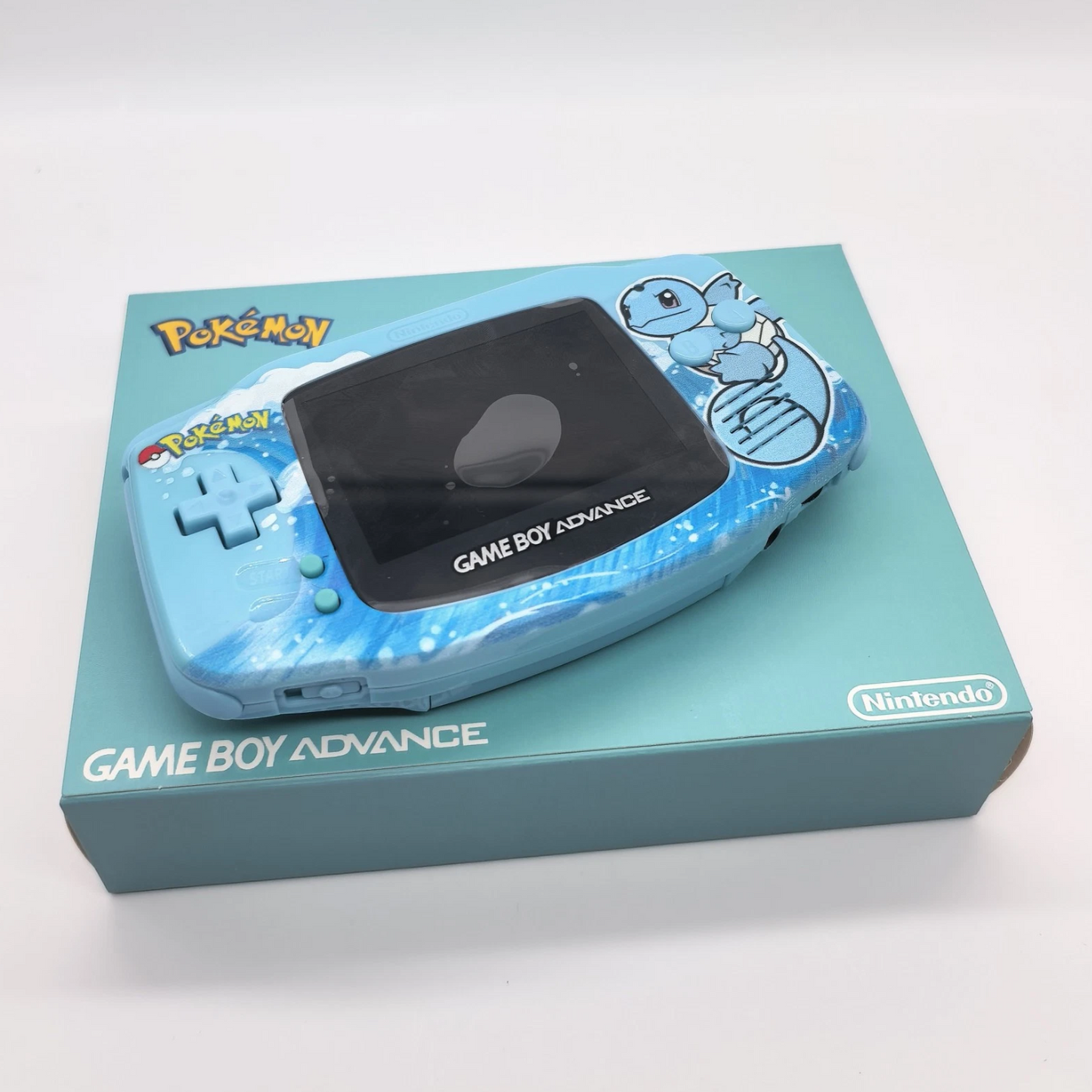 Blue Game Boy Advance with a Pokémon design on a matching box