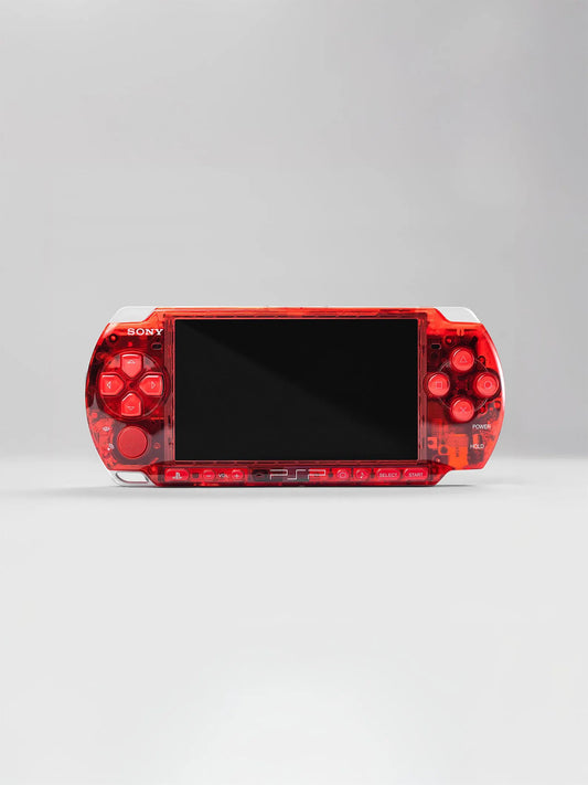 A Seller PSP 3000 (128GB) — 1000+ Games in a Crimson Red Transparent Shell, black screen centered on a light gray background—gaming in style with over 1000 titles.